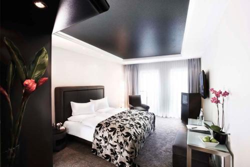 柏林新柏林酒店的一间卧室配有一张带黑白色棉被的床