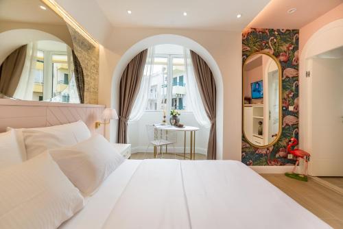 布德瓦Buldero Boutique的卧室配有白色的床和两面镜子