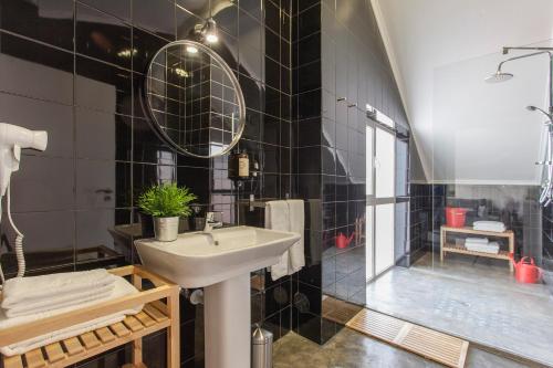 里斯本埃姆珀瑞姆里斯本套房酒店的黑色瓷砖浴室设有水槽和淋浴