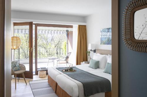 阿斯科纳卡斯特罗索尔海滩Spa度假村的酒店客房设有一张床和一个阳台。