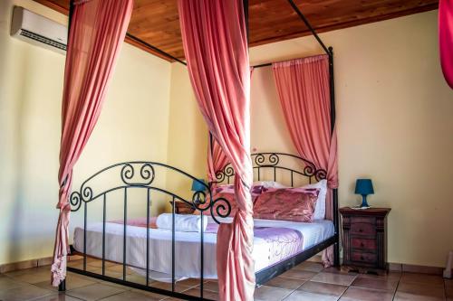 赫索尼索斯尼瑞德斯别墅的一间卧室配有红色窗帘的床
