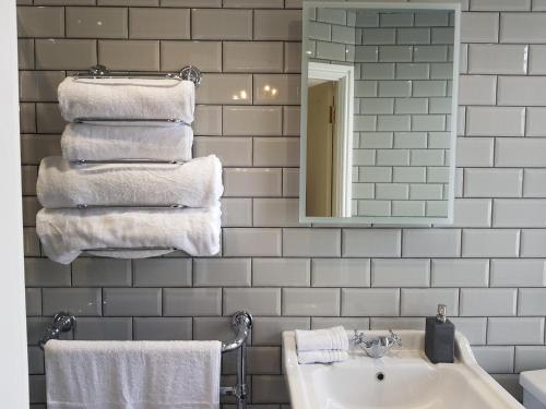 多尔盖罗Afallon Townhouse Gwynedd Room的浴室配有盥洗盆、镜子和毛巾