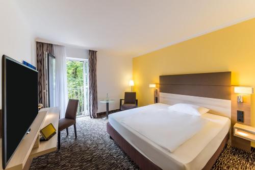 科隆科隆市西雷迪森公园酒店的酒店客房设有一张大床和一台电视机。
