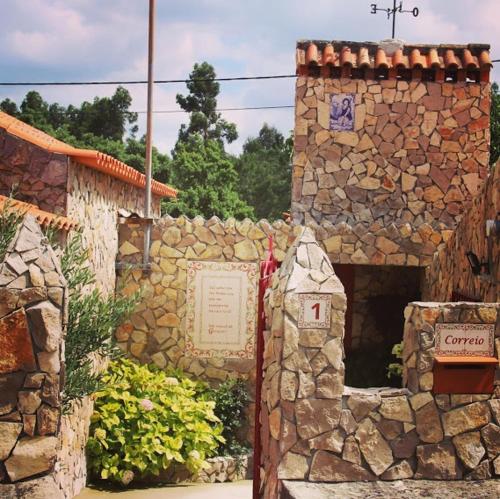 Vale BordaloImperio de Memorias - Casa de Campo的一座石头建筑,前面有标志