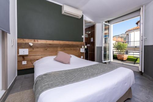 土伦塞伦亚酒店的一间卧室设有一张大床和一个大窗户