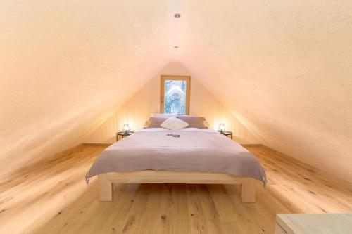 博希尼Bohinj Cottage Pr' Maricki - house in nature with hot tub & sauna的阁楼上的卧室配有一张大床