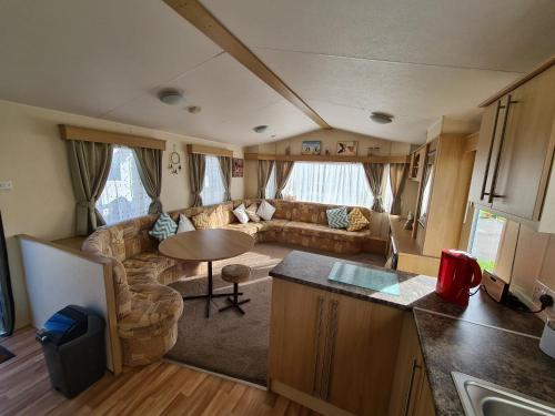 查珀尔圣伦纳兹Golden Palm - Meadow Lakes的客厅配有沙发和大篷车内的桌子