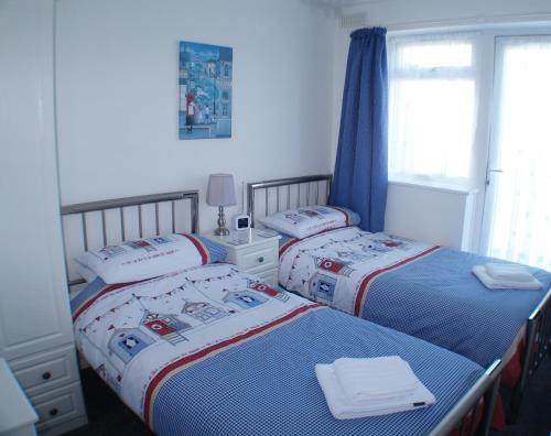 淡水Sunny View, 87 Brambles Chine的一间卧室设有两张床和窗户。