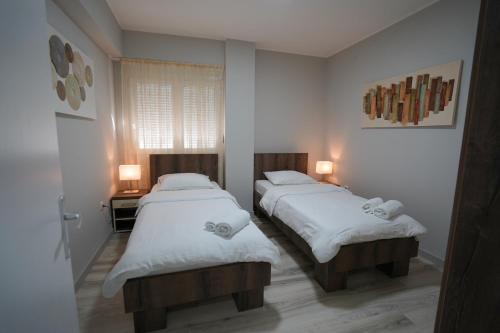 克拉多沃Apartman Nastasijevic的配有白色床单的客房内的两张床