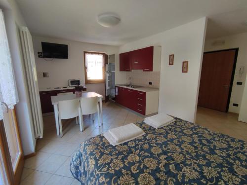 滕诺Residenza Arcobaleno的一间卧室配有一张床,厨房配有桌子