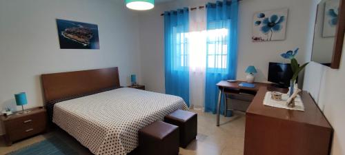 佩尼契Apartamento na Cidade do Surf的一间卧室配有一张床、一张书桌和一台电视