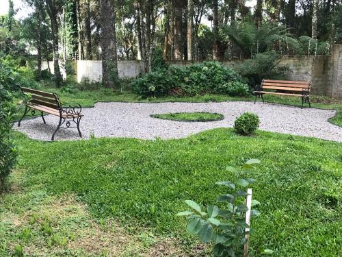 圣弗朗西斯科-迪保拉Piavi Residencial的两个长椅坐在草地公园里