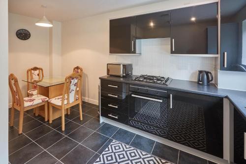 霍姆弗斯Host & Stay - 57 Woodland View的厨房配有桌子和炉灶。 顶部烤箱
