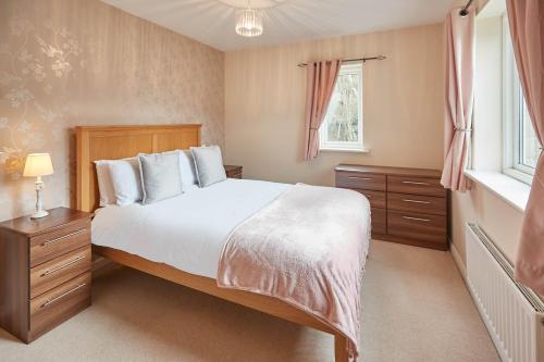 霍姆弗斯Host & Stay - 57 Woodland View的一间卧室设有一张大床和一个窗户。