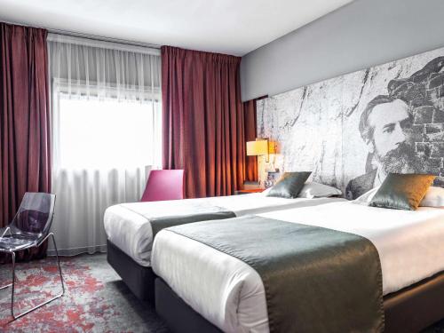贝尔福Mercure Belfort Centre的一间酒店客房,配有两张床和一幅画画