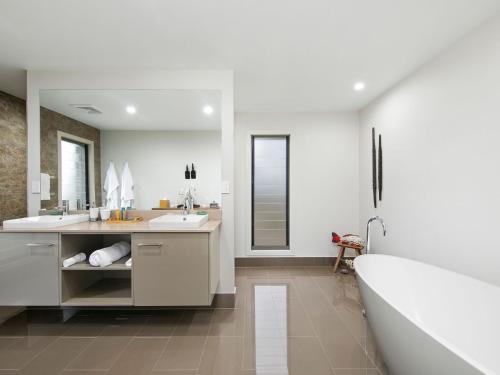 勒弗戴尔百合豪华度假屋的浴室配有两个盥洗盆和浴缸。