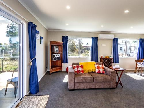 国家公园Bluebird Day - National Park Holiday Home的客厅配有蓝色窗帘和沙发