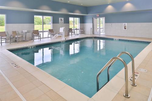 卡特湖奥马哈机场智选假日套房酒店的酒店的大型游泳池配有桌椅