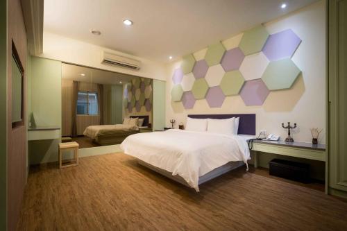 梧栖爱力根汽车旅馆的一间卧室设有一张大床和色彩缤纷的墙壁