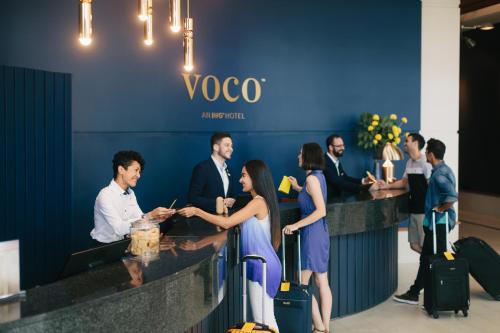 黄金海岸voco Gold Coast, an IHG Hotel的一群站在唱片柜台上的人