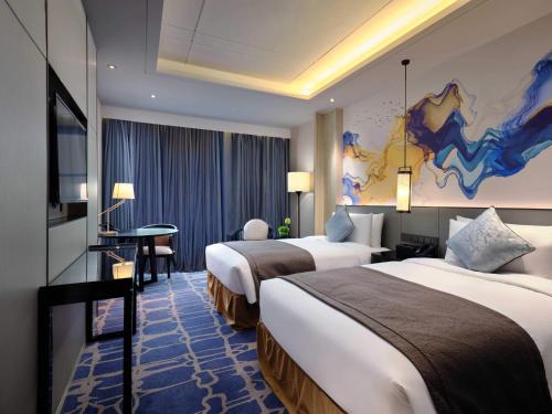 上海上海三甲港绿地铂瑞酒店-提供浦东机场和迪士尼班车的酒店客房配有两张床和一张书桌