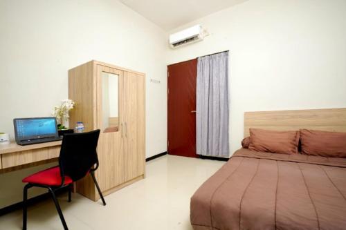 玛琅DPARAGON SONGGOLANGIT的一间卧室配有一张床、一张桌子和一把椅子