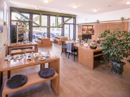 埃斯林根伊库恩酒店的餐厅设有木桌、椅子和窗户。
