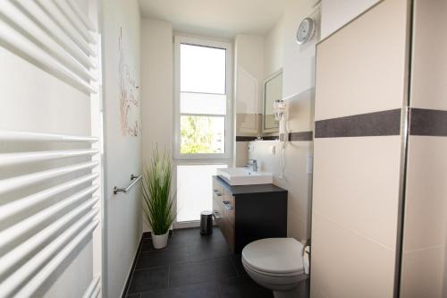 格洛韦Ferienwohnung Auszeit的一间带卫生间、水槽和窗户的浴室