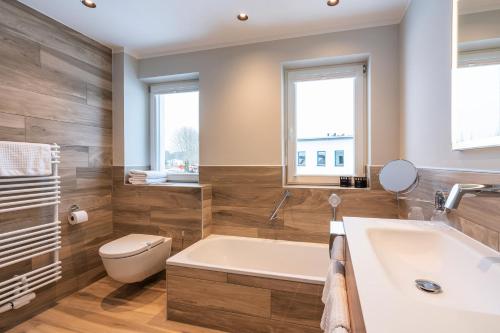 特拉森海德TUI SUNEO Kinderresort Usedom的带浴缸、卫生间和盥洗盆的浴室