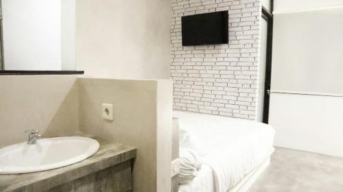 梭罗DPARAGON KERTEN的一间带白色水槽和砖墙的浴室