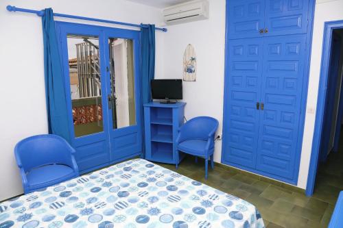 莱斯卡拉Pensió Solivent的卧室设有蓝色门、一张床和电视。