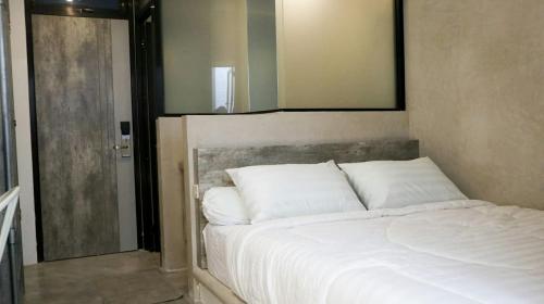 泗水DJURAGANKAMAR GUNUNG ANYAR的卧室内的一张带白色枕头的床