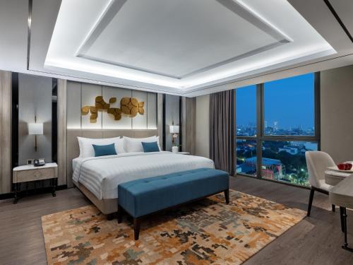 日惹Royal Malioboro by ASTON的一间卧室设有一张床和一个大窗户