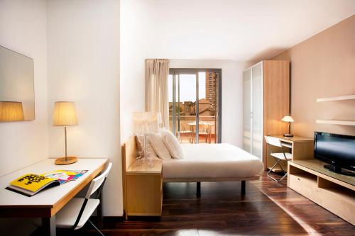 巴塞罗那巴塞罗那阿拉姆特公寓酒店的一间卧室配有一张床、一张书桌和一台电视