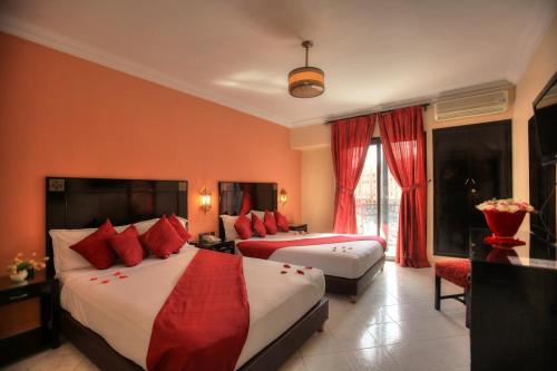 马拉喀什蒙特古里兹酒店及水疗中心的酒店客房 - 带两张带红色枕头的床