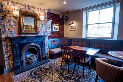 索尔塔什Brunel Inn的餐厅设有壁炉、桌子和镜子