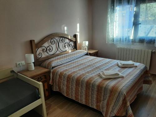 卡萨雷斯德拉斯乌尔德斯Alojamientos Rurales Hurdes Altas - La Antigua Guarderia的一间卧室配有一张床,上面有两条毛巾