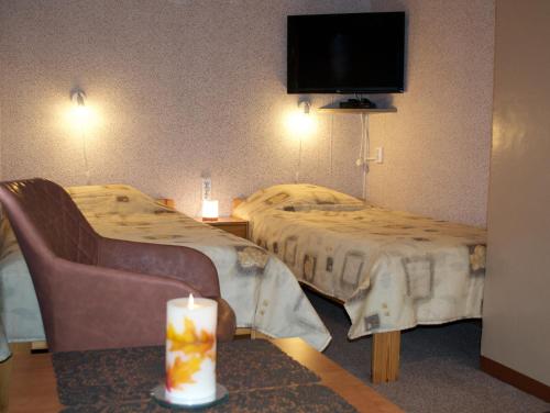 库雷萨雷Nooruse Majutus的酒店客房设有两张床和一张桌子上的蜡烛