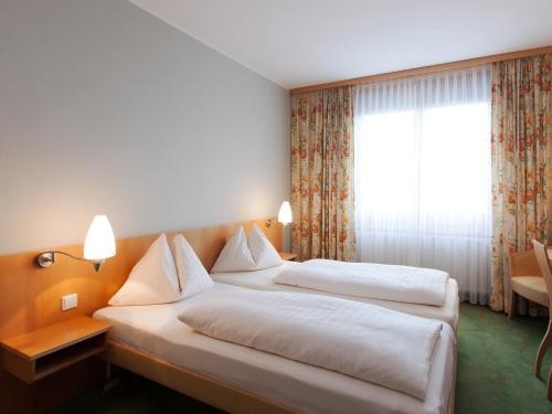 萨特勒特沃拉本阔兹乡村餐厅酒店的酒店客房设有两张床和窗户。