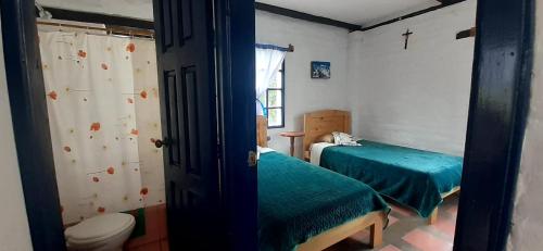 MachachiHostería Chíguac的小房间设有两张床和卫生间