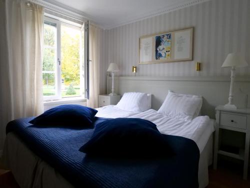 格内斯塔索德图纳城堡酒店的一间卧室配有带两个枕头的床和窗户