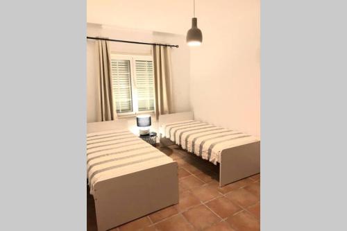萨尔堡Vila Nova de Santa Susana - Resort的带窗户的客房内的两张床