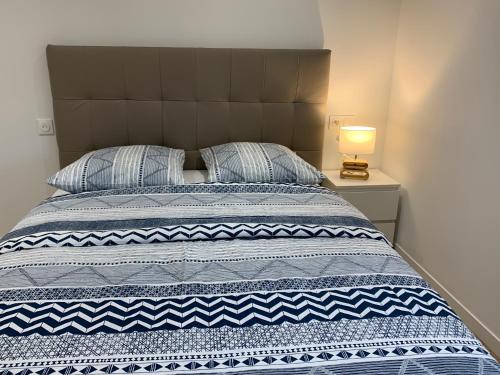 楠泰尔Nanterre Room的一张带蓝色和白色毯子和灯的床