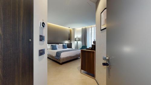 米兰GALLERIA The Smart Boutique APARTHOTEL By OSPITAMI的一间酒店客房,设有一张床和一扇通往卧室的门