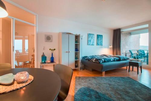 哈里斯莱fewo1846 - FoerdeNest - familienfreundliche Wohnung mit 2 Balkonen und Meerblick的一间卧室配有一张床,另一间用餐室配有桌子