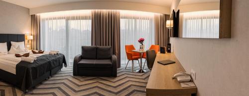 斯维诺乌伊希切Hamilton SPA & Wellness的酒店客房配有一张床、一把椅子和一张书桌