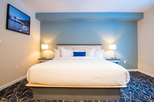 西沃德Gateway Hotel的卧室配有白色大床和蓝色的墙壁
