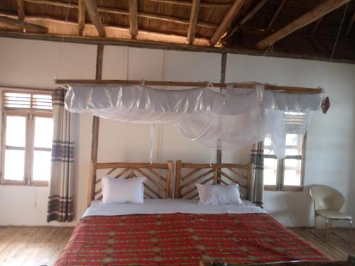 KatunguruTembo Safari Lodge的一间卧室配有一张带天蓬的大床