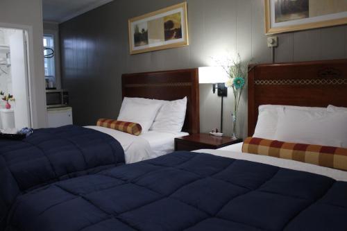 帕里桑德Sunrise Inn的酒店客房,配有两张带蓝色床单的床