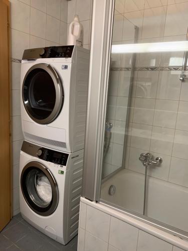 劳特布龙嫩Ferienwohnung Talhaus的带淋浴的浴室内的洗衣机和烘干机